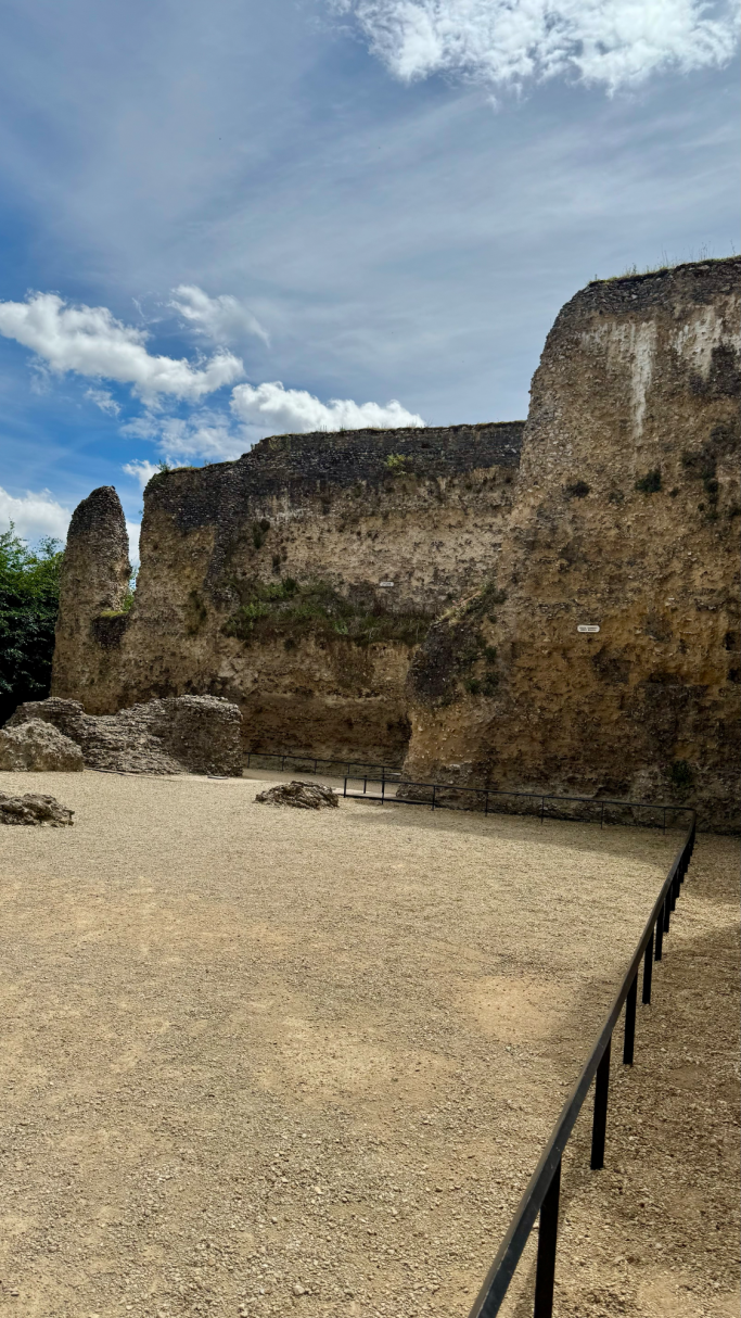 Ancient stone ruins with a clear blue sky and scattered clouds.
