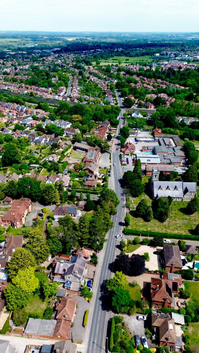 Aerial view of a residential area with trees and houses lining the streets.